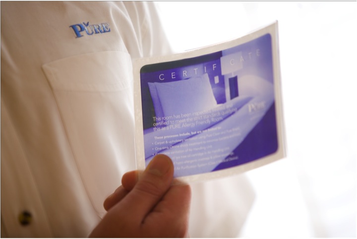 image of a hand holding a PURE certification card