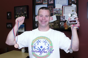 Tim poses with his medals from the 2012 Special Olympics